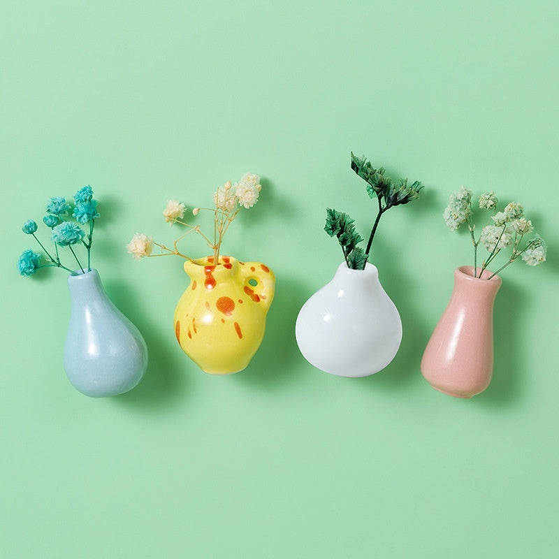 Four small vases with plants on a green background