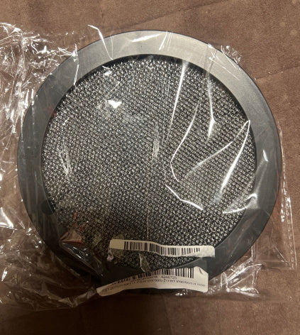 Round metallic filter in clear plastic wrap on a brown surface