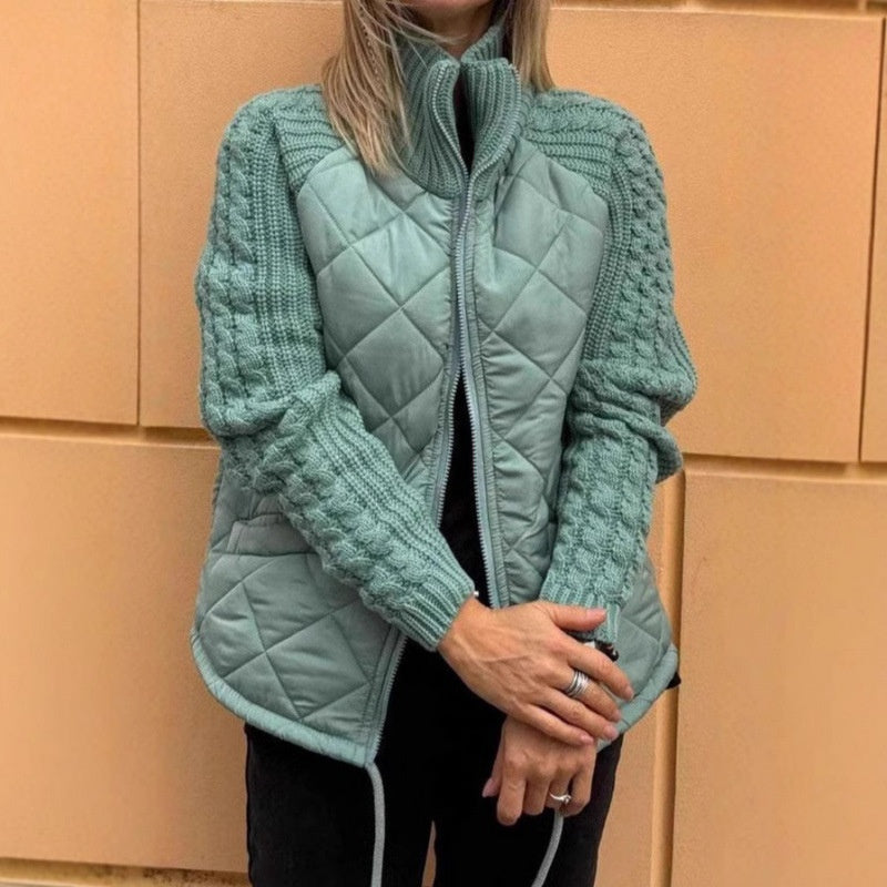 Person wearing a light blue quilted jacket against a beige wall.