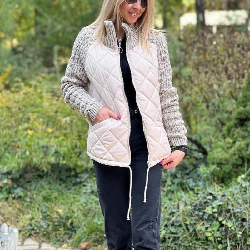 Woman wearing a white quilted vest over a gray knit cardigan in an outdoor setting.
