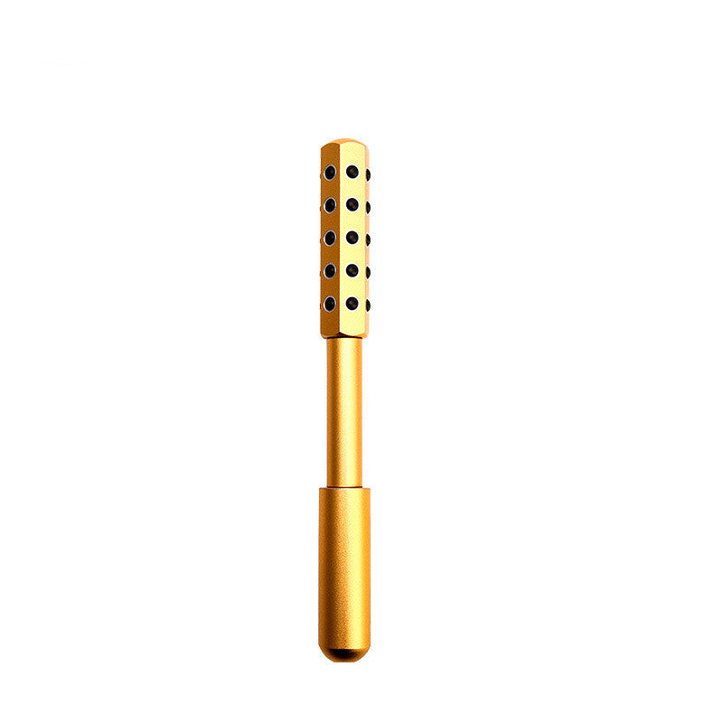 Gold-colored tool with black dots on a white background