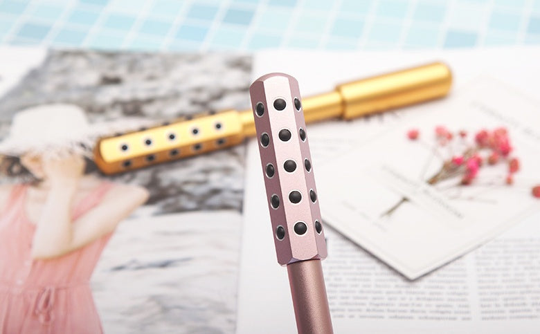 Rose gold hairbrush with decorative handle on a magazine background