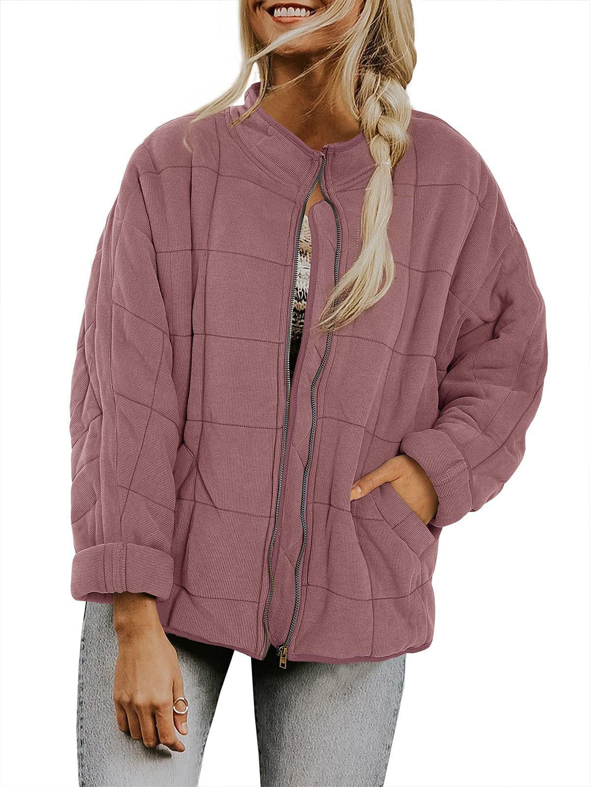 Person wearing a pink quilted jacket on a white background