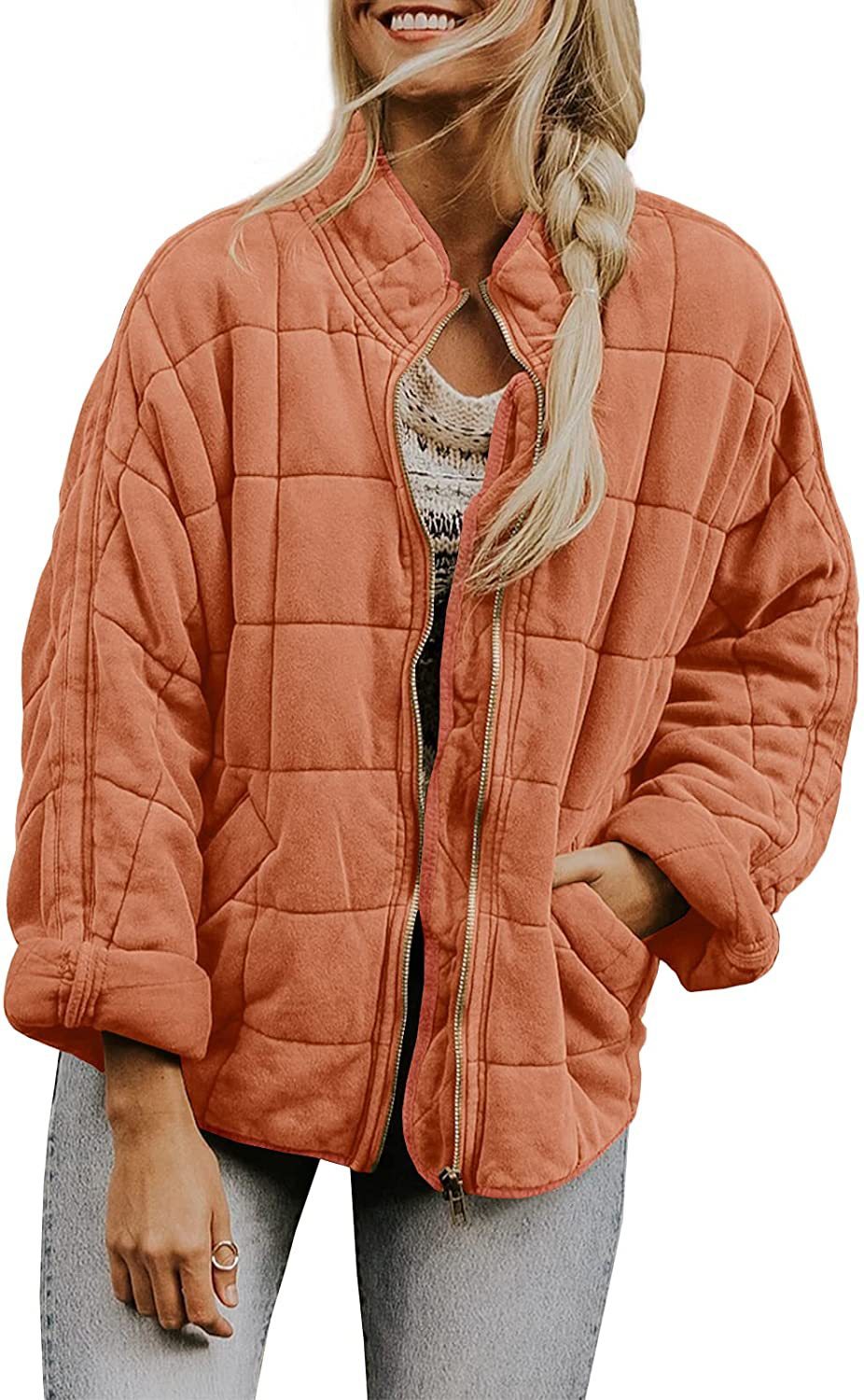 Woman wearing a quilted orange jacket on a white background