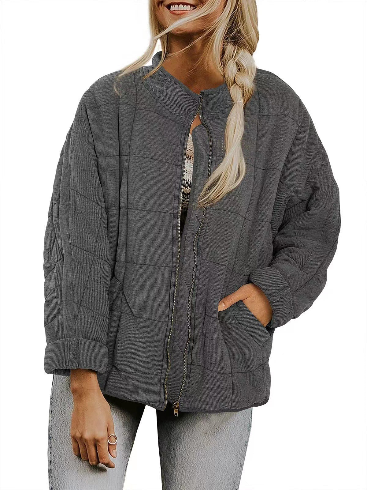 Person wearing a gray zip-up hoodie on a white background