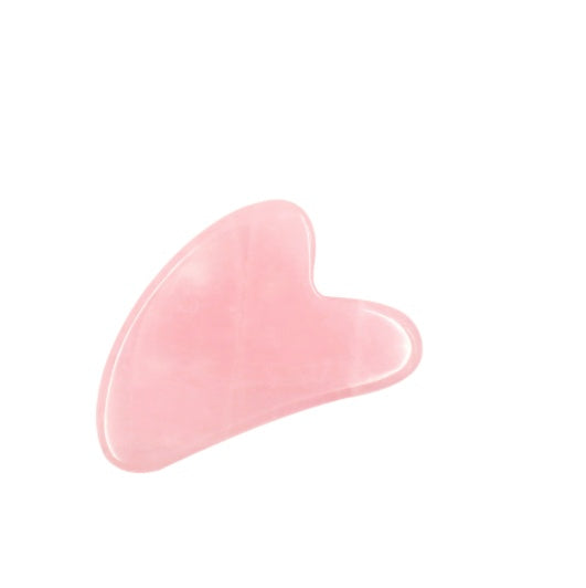 Pink gua sha tool on a white background
