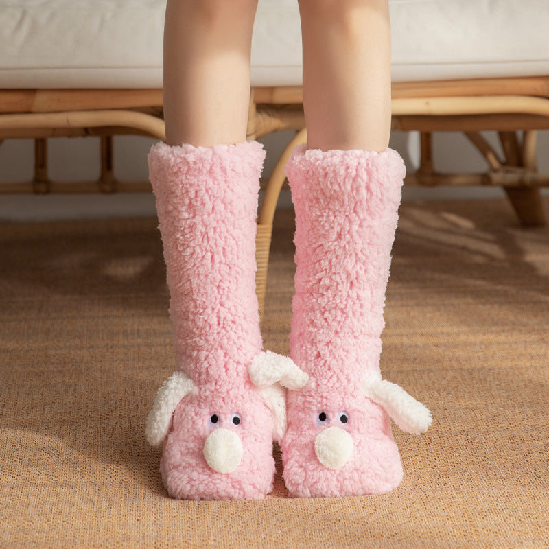 Pink fuzzy slippers with animal faces worn by a person indoors.