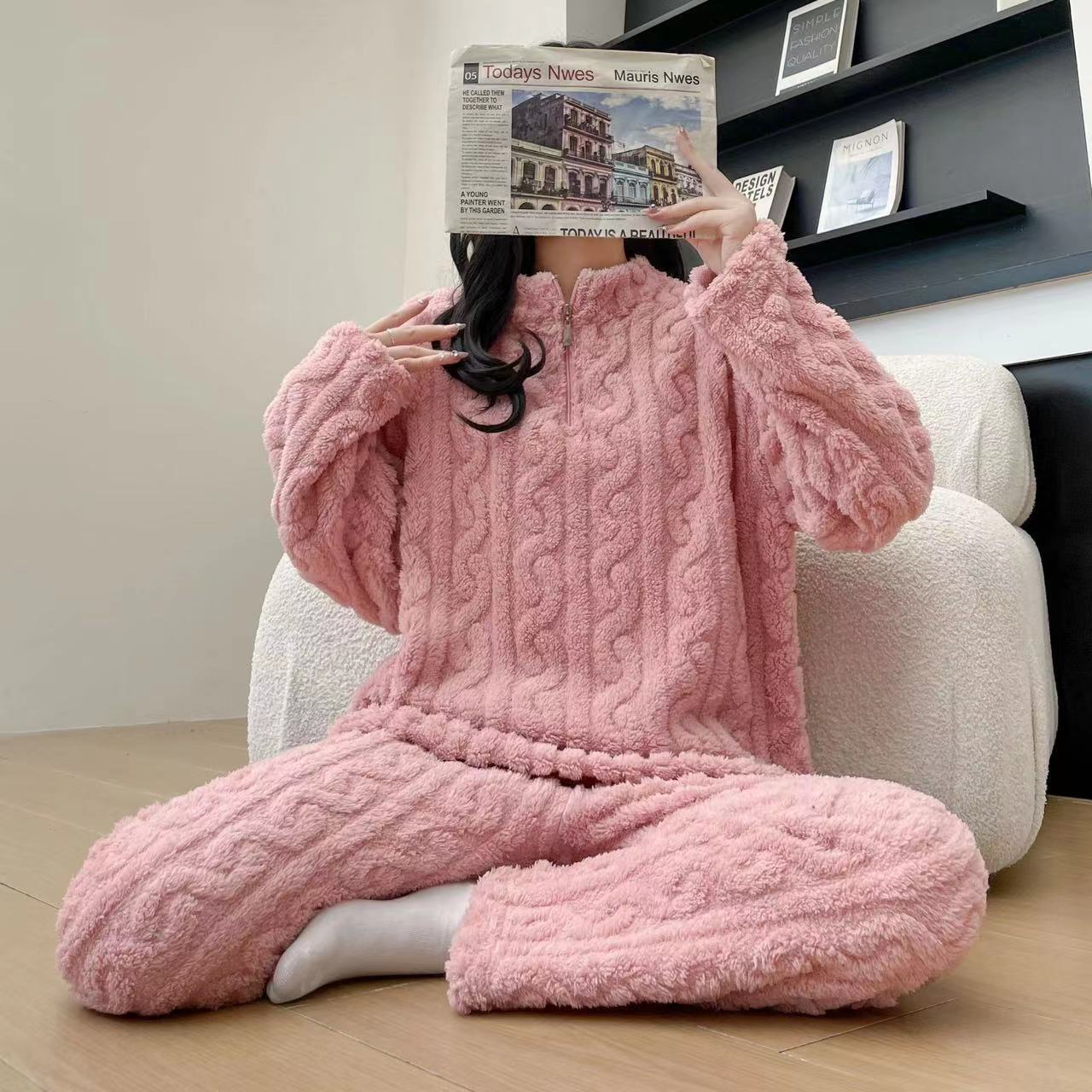 Person wearing a pink cable knit loungewear set sitting on a white couch.