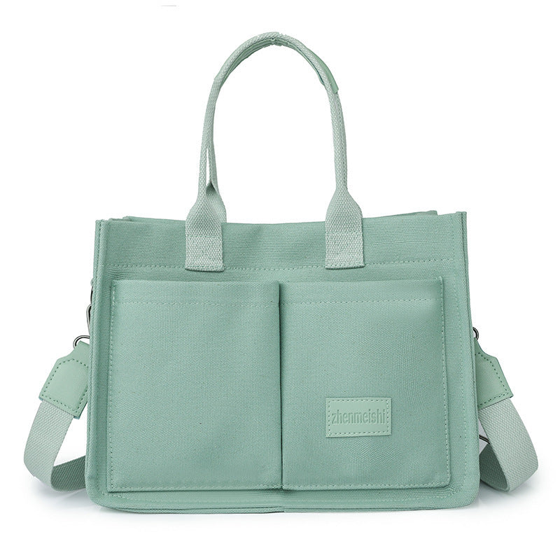A collection of canvas tote shoulder bags in various colors, displayed in multiple pockets and with adjustable shoulder straps, showcased in a vertical format.