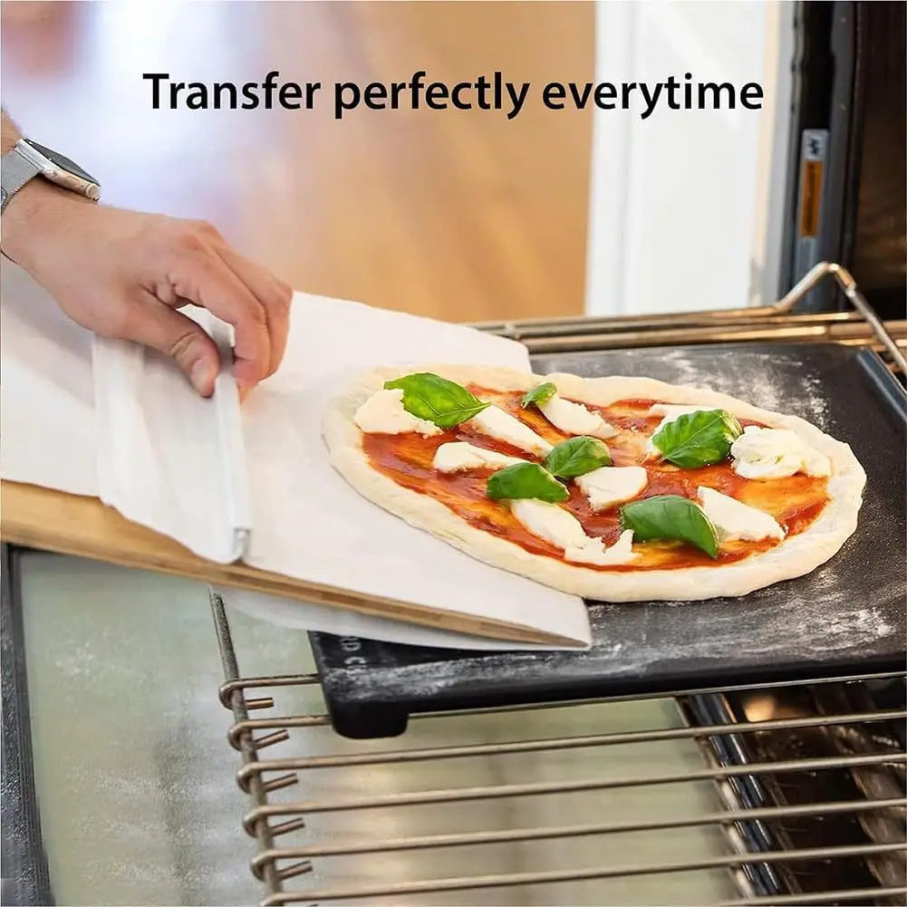 Person placing a pizza on a stone with text 'Transfer perfectly everytime' in a kitchen setting.