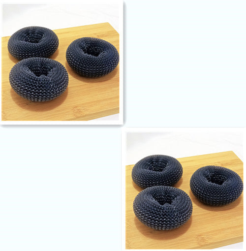 Three black donut-shaped coasters on a wooden board with a white background.