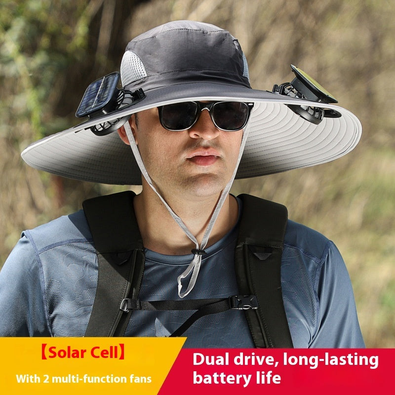 Person wearing a large sun hat with solar cell and fans, outdoors.