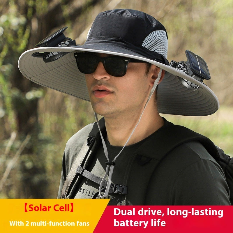 Person wearing a wide-brimmed hat with solar cell and fans, outdoors.