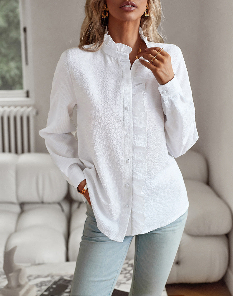 Woman wearing a white button-up shirt and light blue jeans in a living room setting.