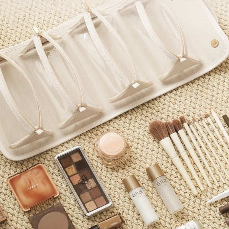 Makeup products including brushes and palettes on a textured surface