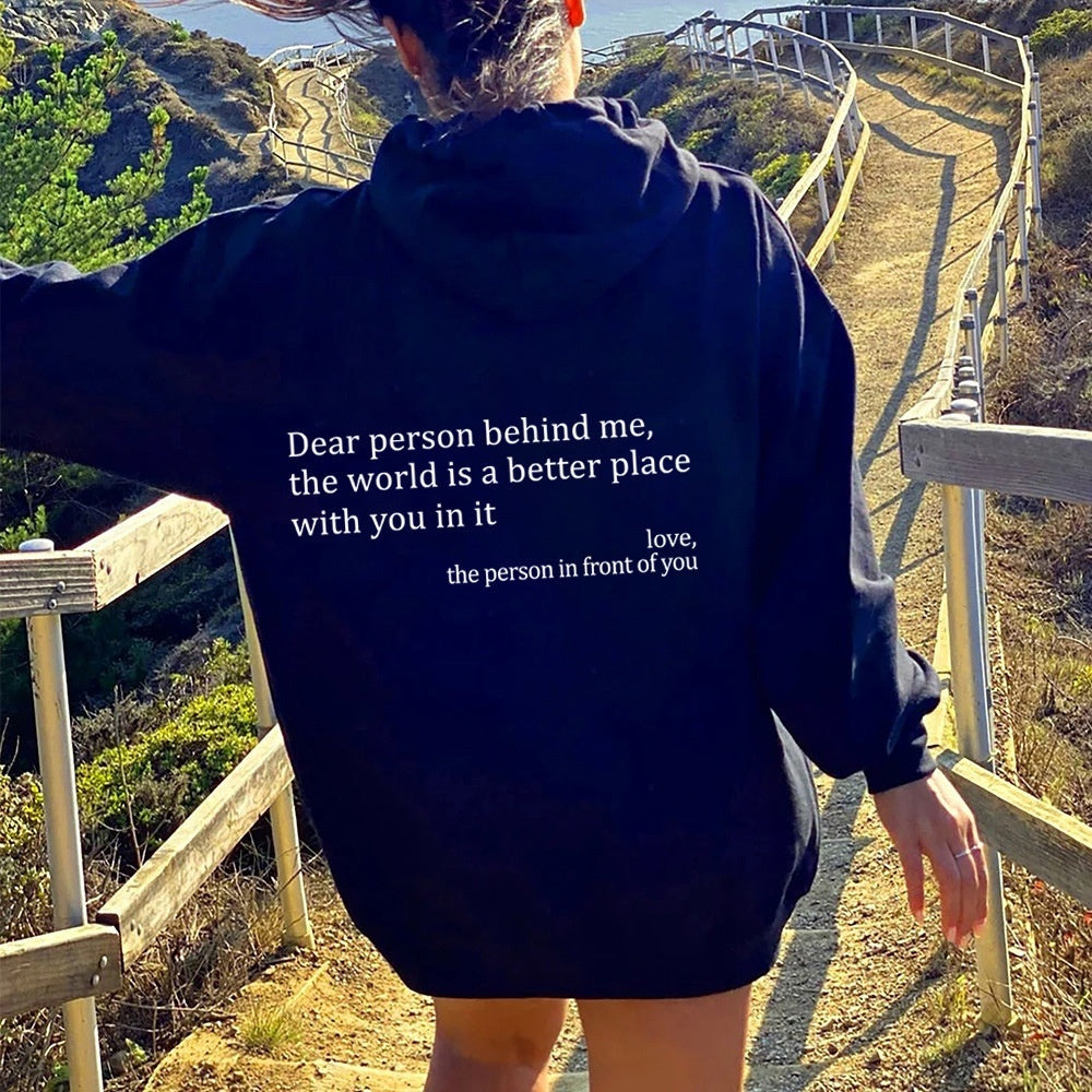 Person wearing a hoodie with a motivational message on a scenic trail.