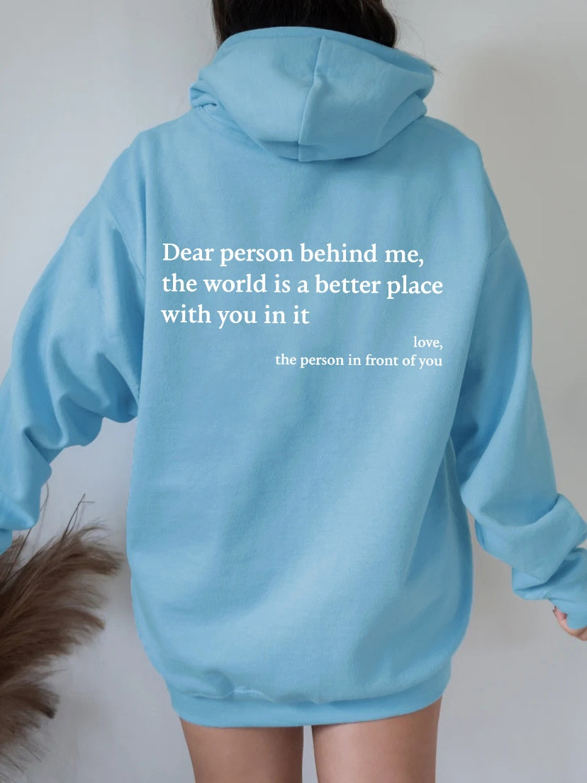 Light blue hoodie with a motivational quote on the back, worn by a person against a plain background.