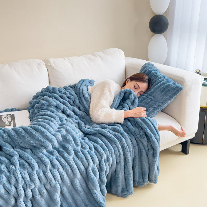 Woman sleeping on a white couch with a blue blanket