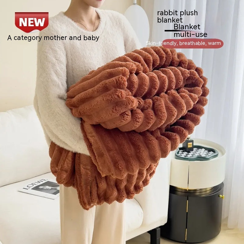 Person holding a brown plush blanket with product details on a light background