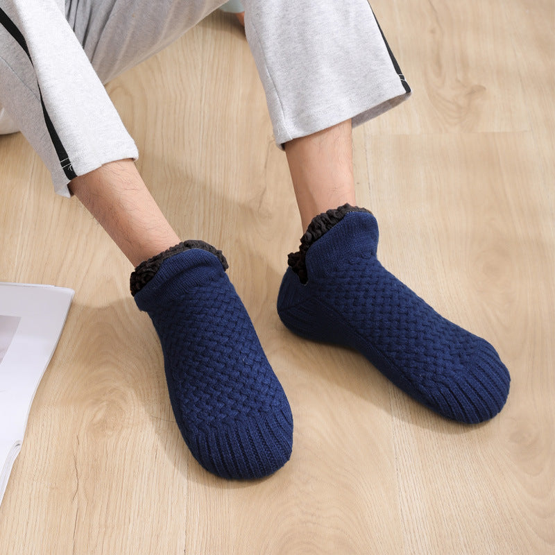 Navy blue textured socks worn by a person on a wooden floor.