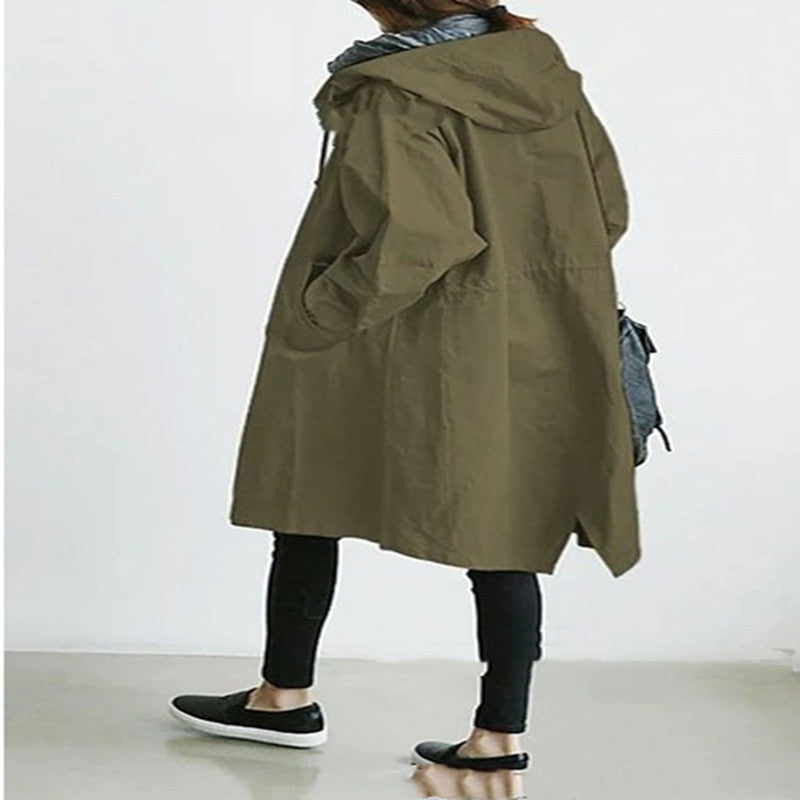 Person wearing a long olive green coat on a white background