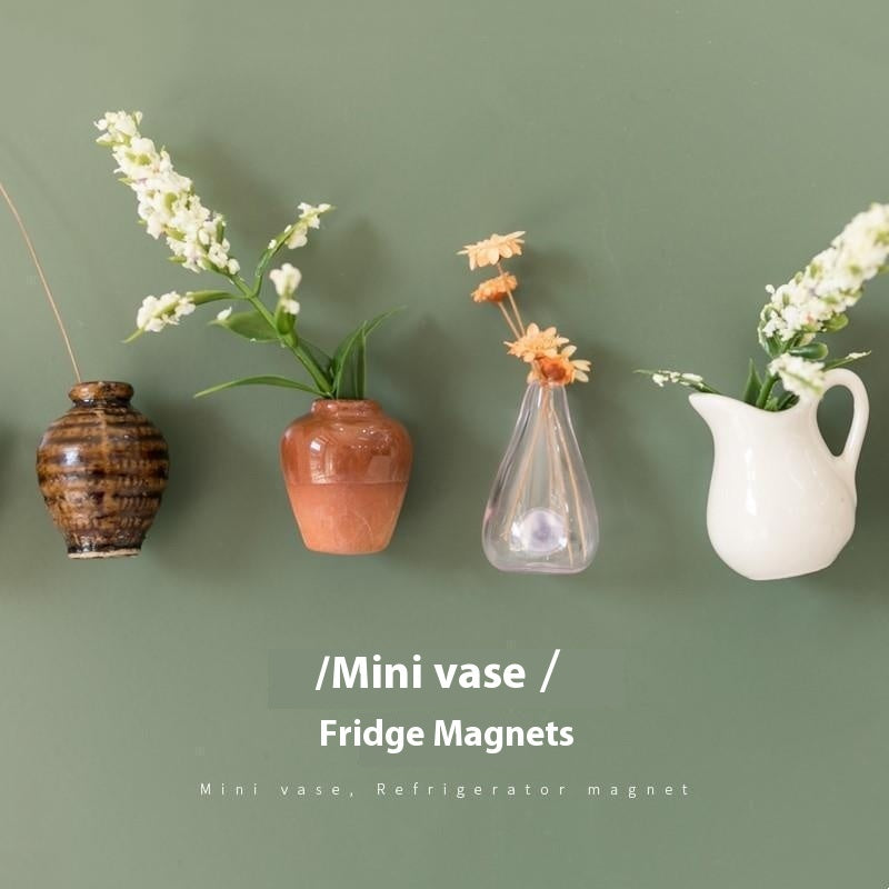 Miniature vases displayed on a green wall with text indicating they are fridge magnets.