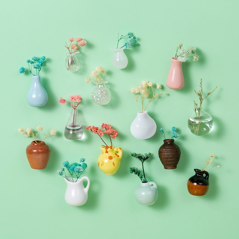 Collection of various small vases with plants on a light green background