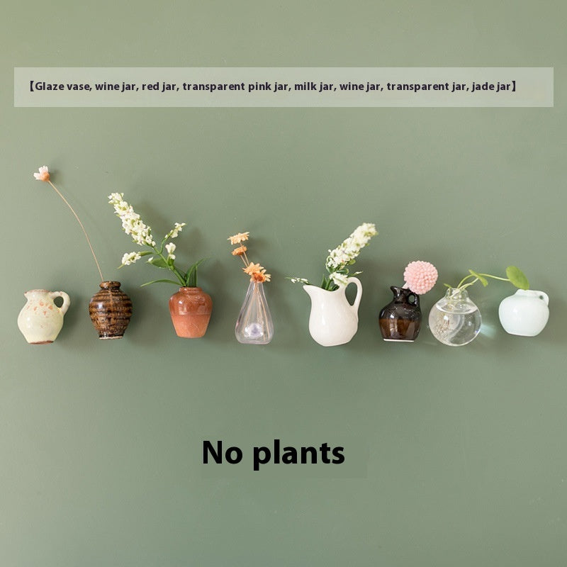 Row of various vases with plants against a green background